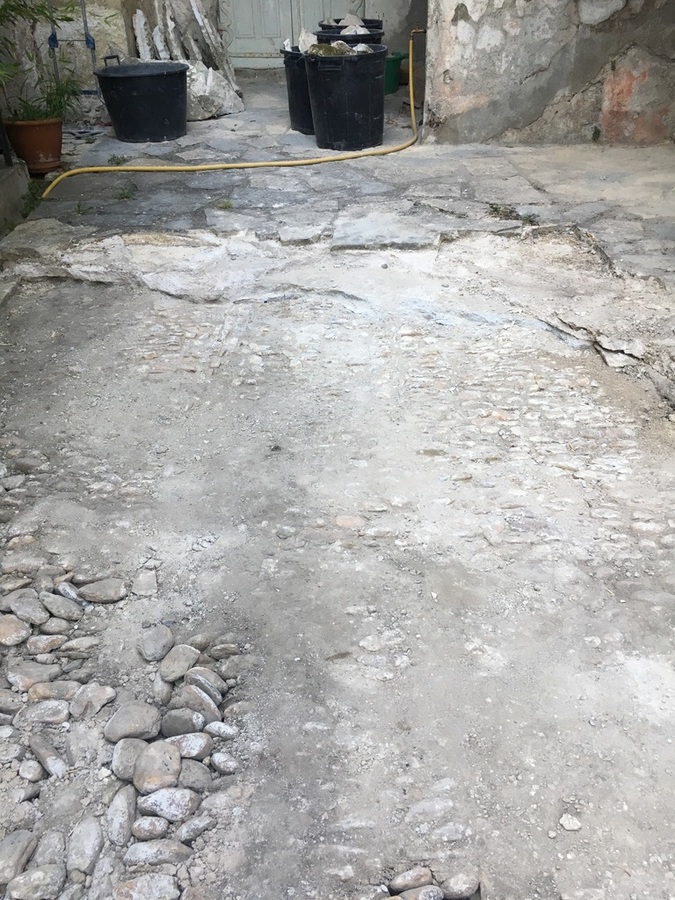 Découverte d'une calade en galets sous un dallage en pierres de Pompignan